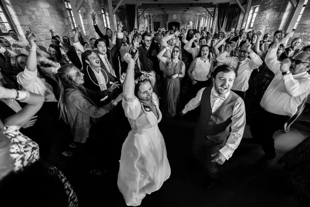 Les mariés et leurs invités sur la piste de danse, en noir et blanc