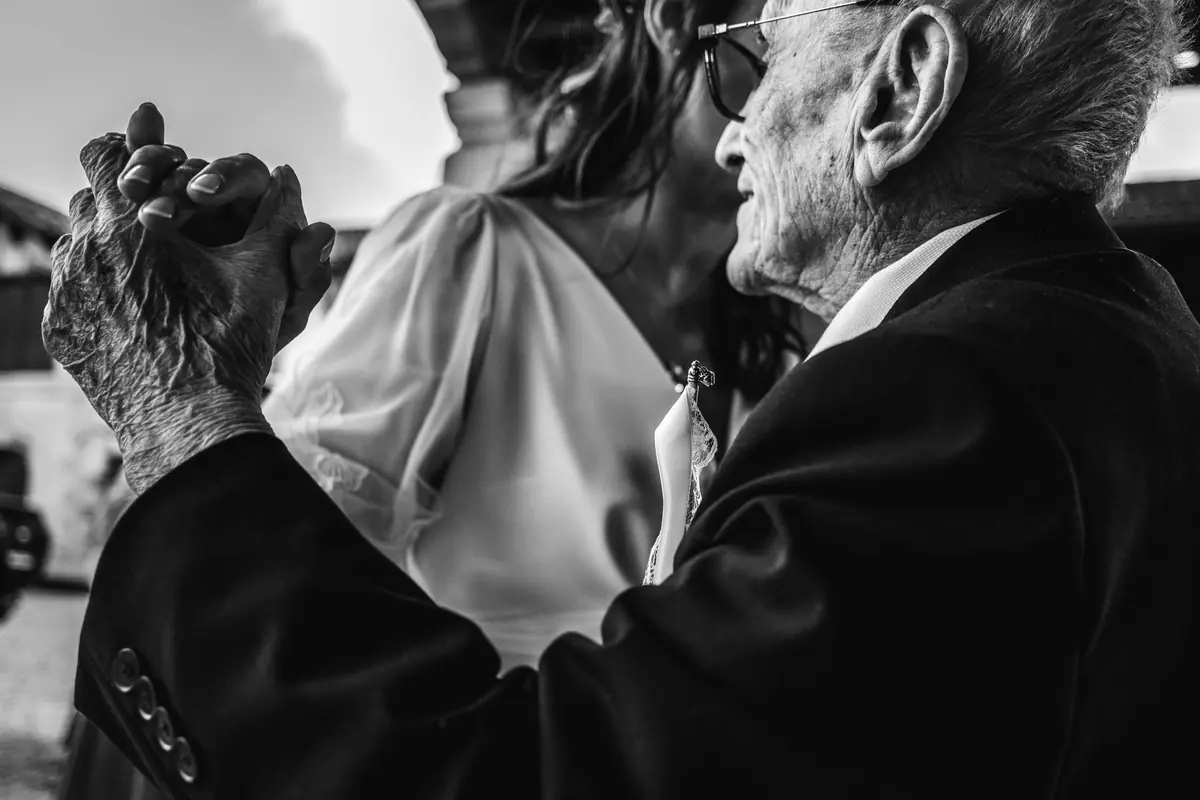Deux invités enlacés, mains jointes, en noir et blanc