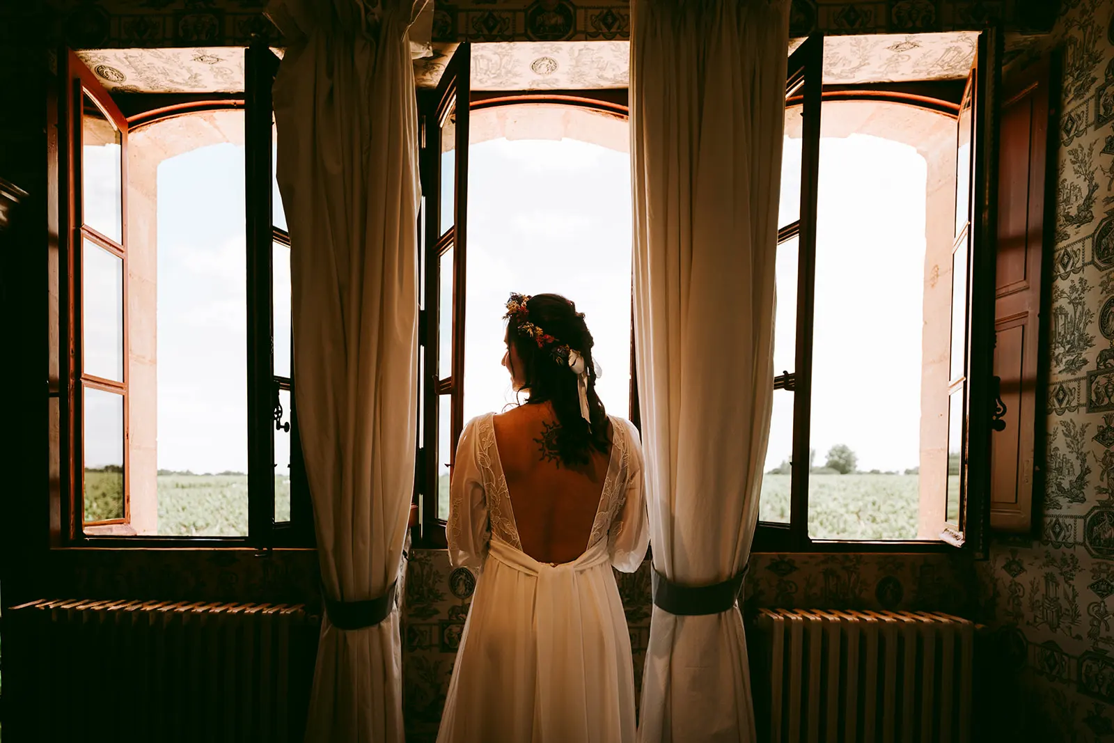 Mariée à contre-jour devant une fenêtre au château Giscours