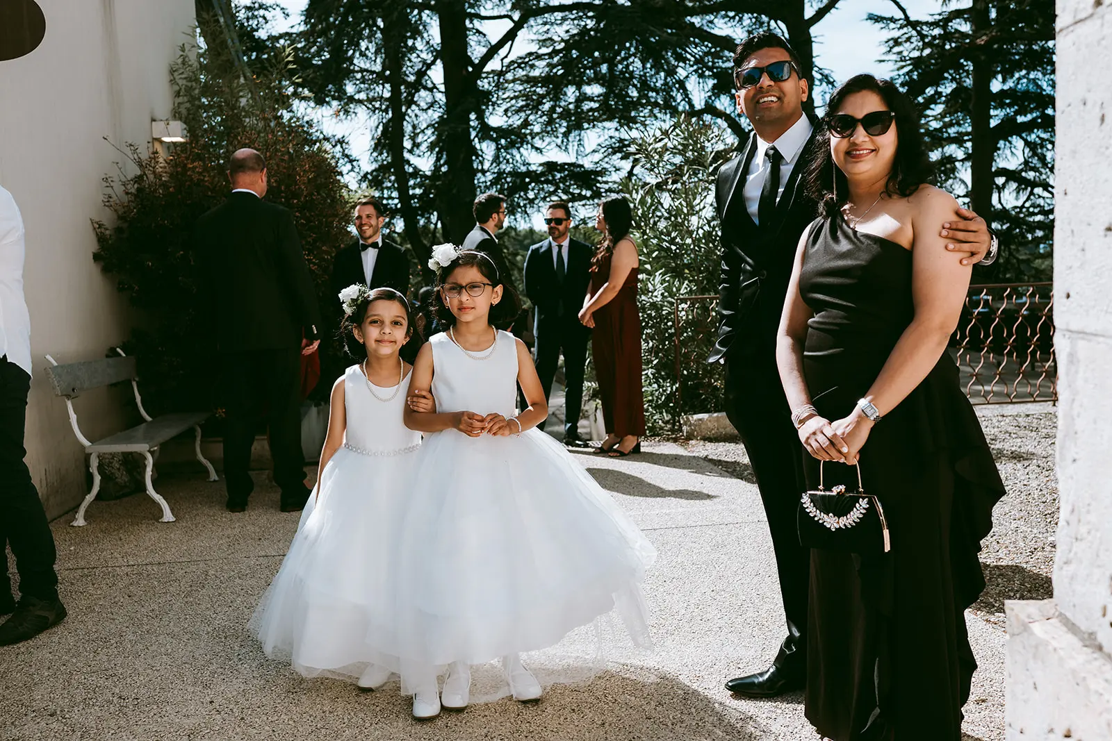 A flower girl in a white dress among the guests