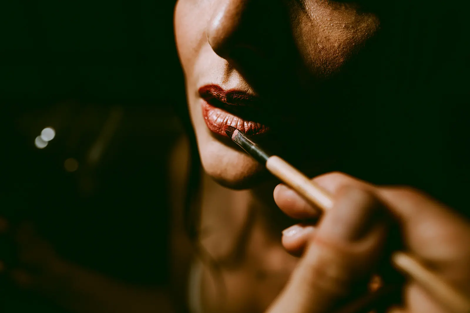 Close-up of the bride putting on lipstick