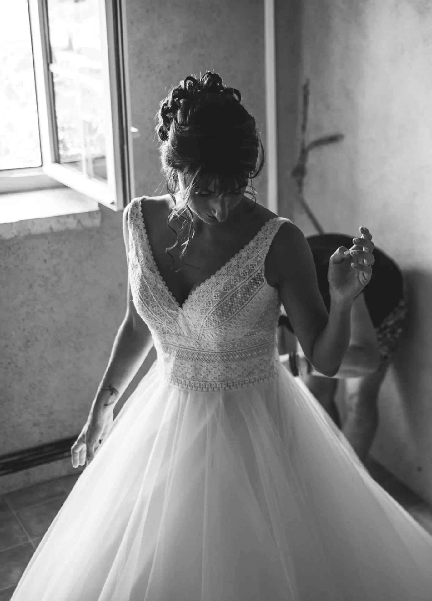 Mariée devant la fenêtre pendant les préparatifs, mariage dans le Gers