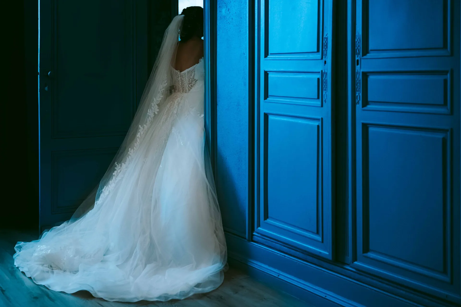 Mariée devant une porte bleue dans un château