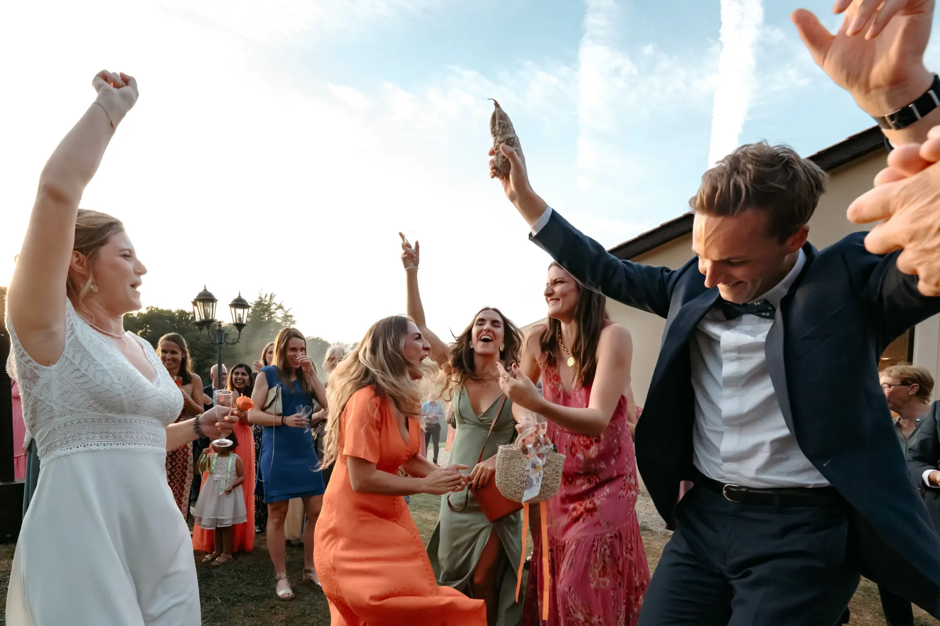 Mariés et invités qui dansent en plein air